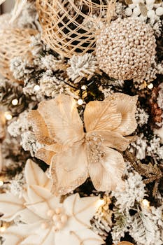 Close-up of elegant Christmas tree decorations featuring lights, flowers, and frosted branches.