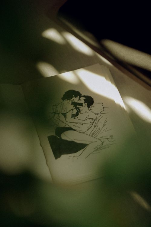 Free A romantic drawing of a couple kissing, surrounded by shadow and sunlight on paper. Stock Photo