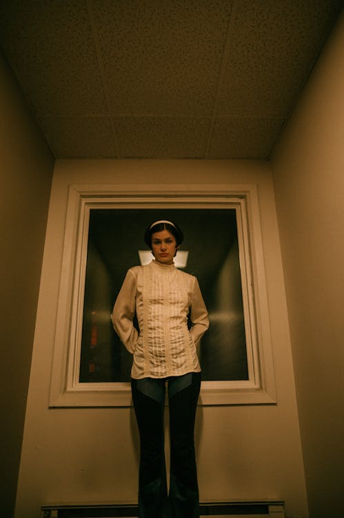 Woman in a Blouse Standing with her Hands Behind her Back