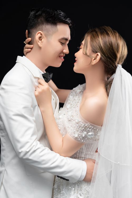 Free Elegant Asian bride and groom embrace during studio wedding photoshoot. Stock Photo