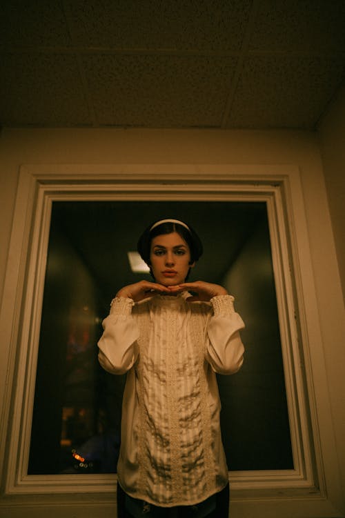 Woman in a Blouse Posing with her Hands by her Face