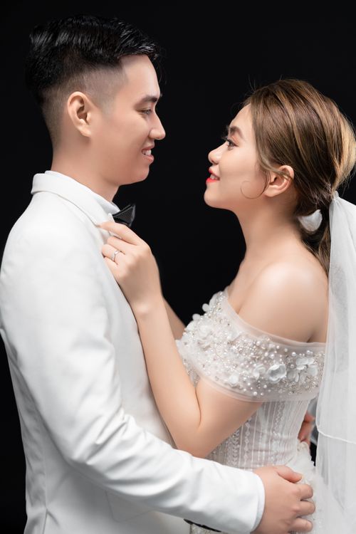 Free Bride and groom in formal attire embracing with smiles in a portrait shot. Stock Photo