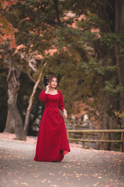 
Woman in Red Dress Walking on Road
