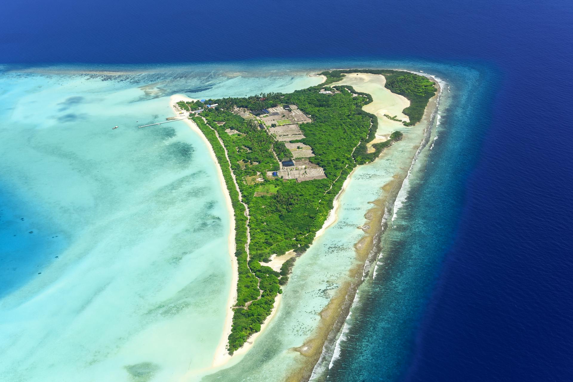 A breathtaking aerial view of a lush tropical island surrounded by turquoise waters.