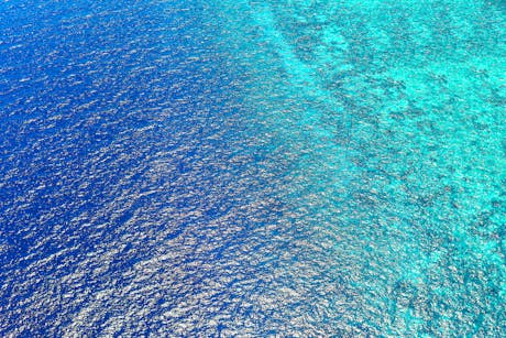 Stunning aerial view capturing the vibrant blue ocean waters of Central Kalimantan, Indonesia.