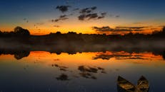 日落时，湖面宁静，倒影充满活力，氛围朦胧