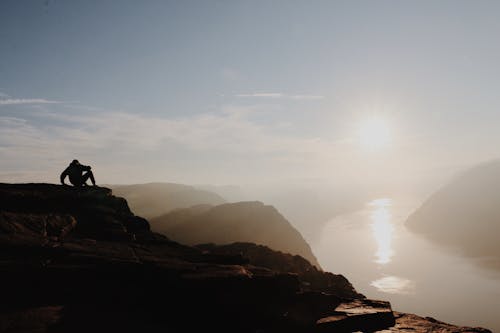 A Person Sitting on the Mountain Top