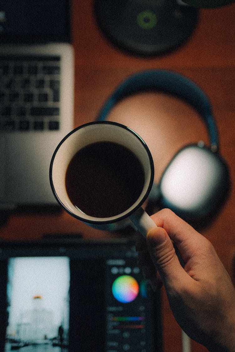 Overhead Shot Of A Person's Hand Holding A Cup Of Coffee