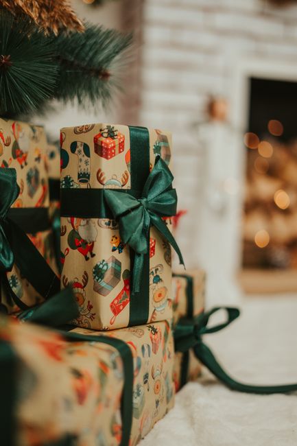 Close-up of beautifully wrapped Christmas gifts with green ribbons and holiday-themed paper.