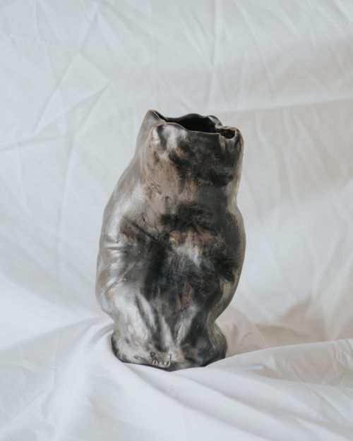 Free A unique handmade ceramic vase with earthy tones on a white fabric background. Perfect for decor. Stock Photo