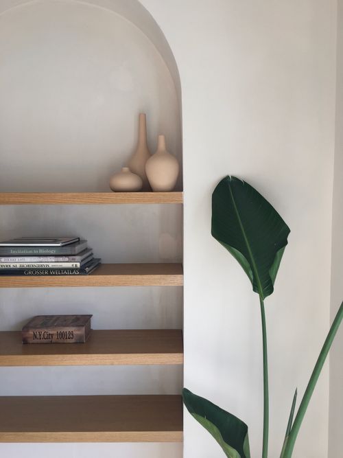 Free Elegant minimalist bookshelf featuring books, decorative vases, and a green plant in a bright, modern interior. Stock Photo