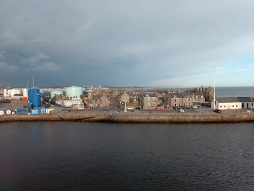 Brown and White Buildings Near Body of Water