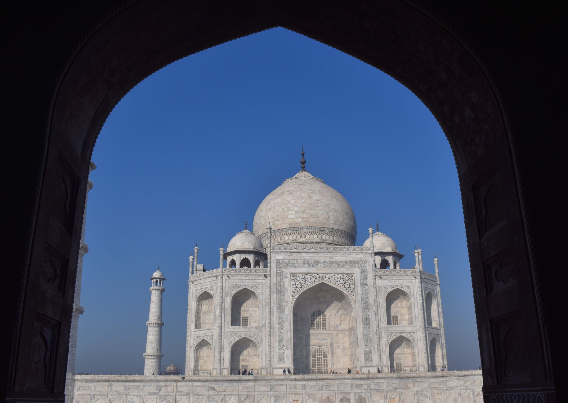 Stunning image of the Taj Mahal framed by an arch, showcasing its architectural beauty against a vibrant blue sky. — free online jigsaw puzzle on JigsawPuzzlesFreeOnline.org
