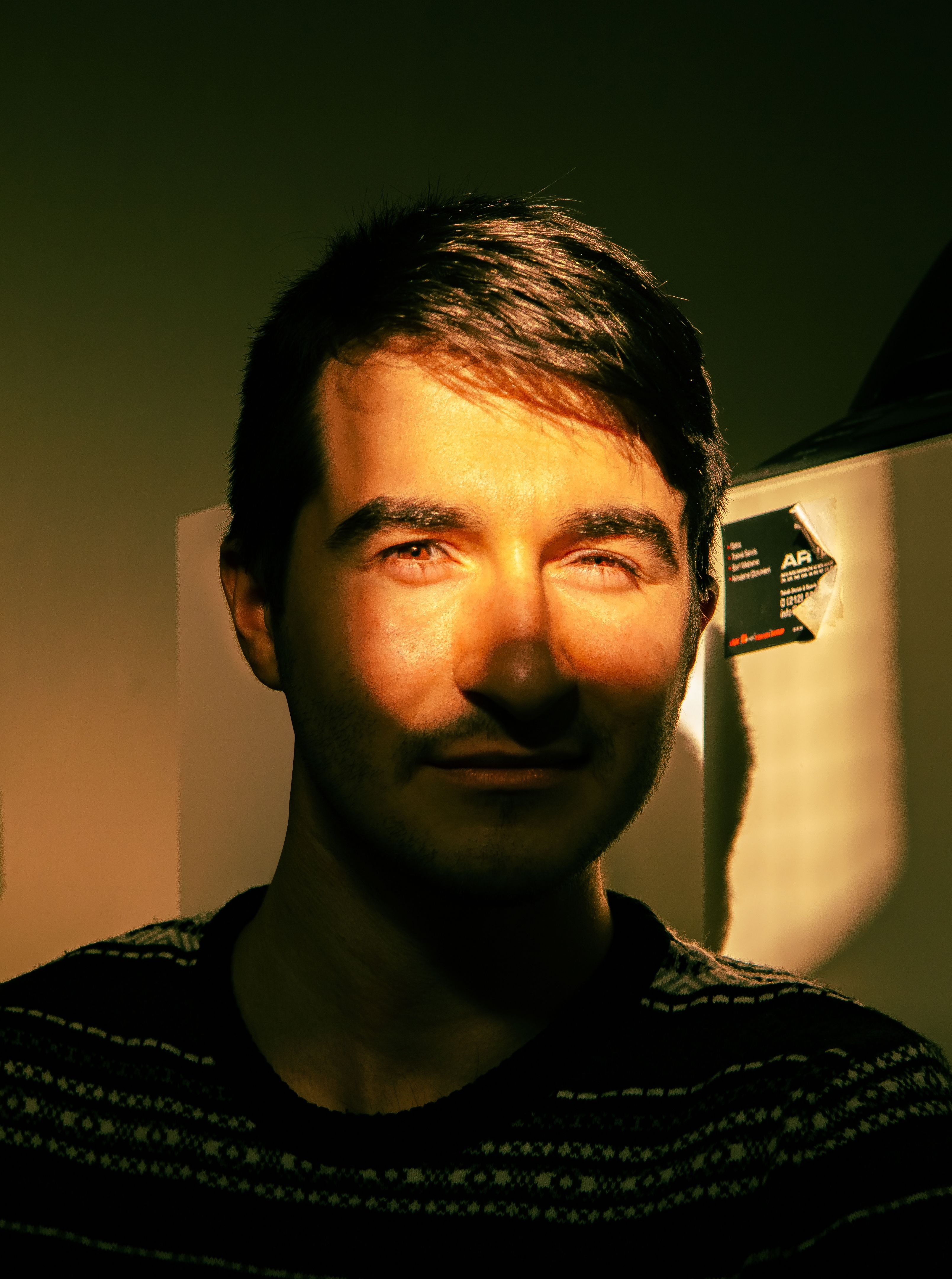 Portrait of a man with a dramatic mix of shadow and light.