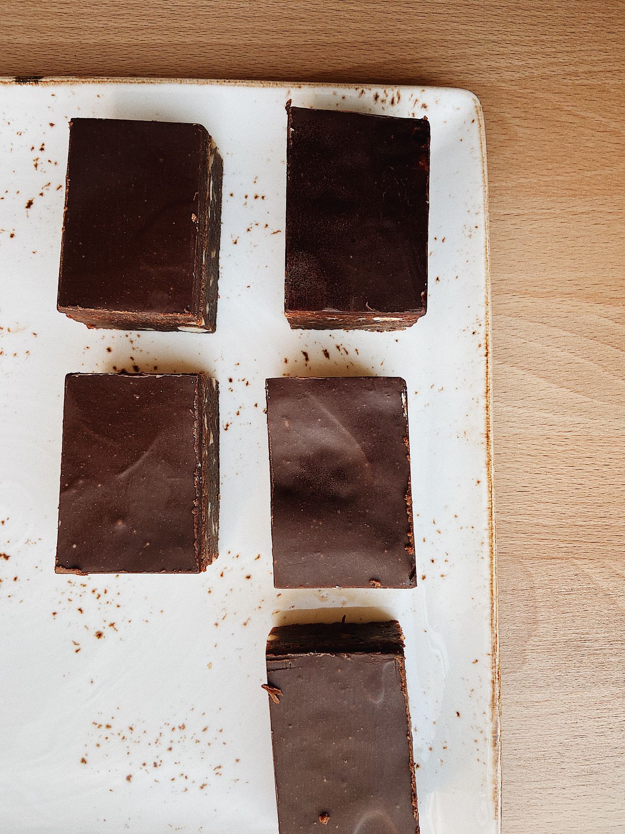 Chocolate-topped layered bars on a white plate