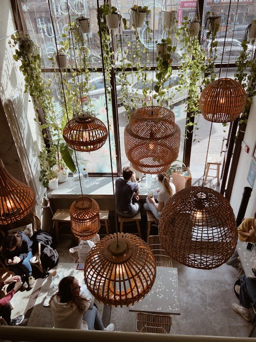 People Sitting Inside a Room with Hanging Rattan Pendant Lamps