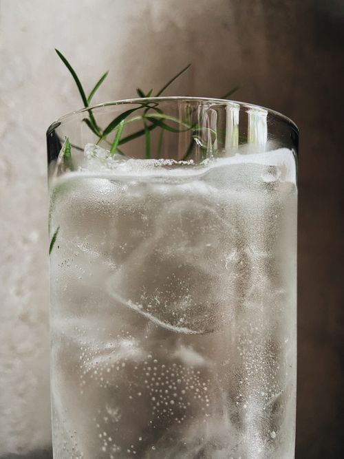 Free Close-up of a tall glass with sparkling water, ice, and fresh herbs. Stock Photo