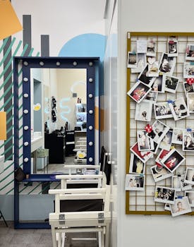 Colorful salon interior featuring a vanity mirror and a wall of polaroid photos, capturing artistic ambiance.
