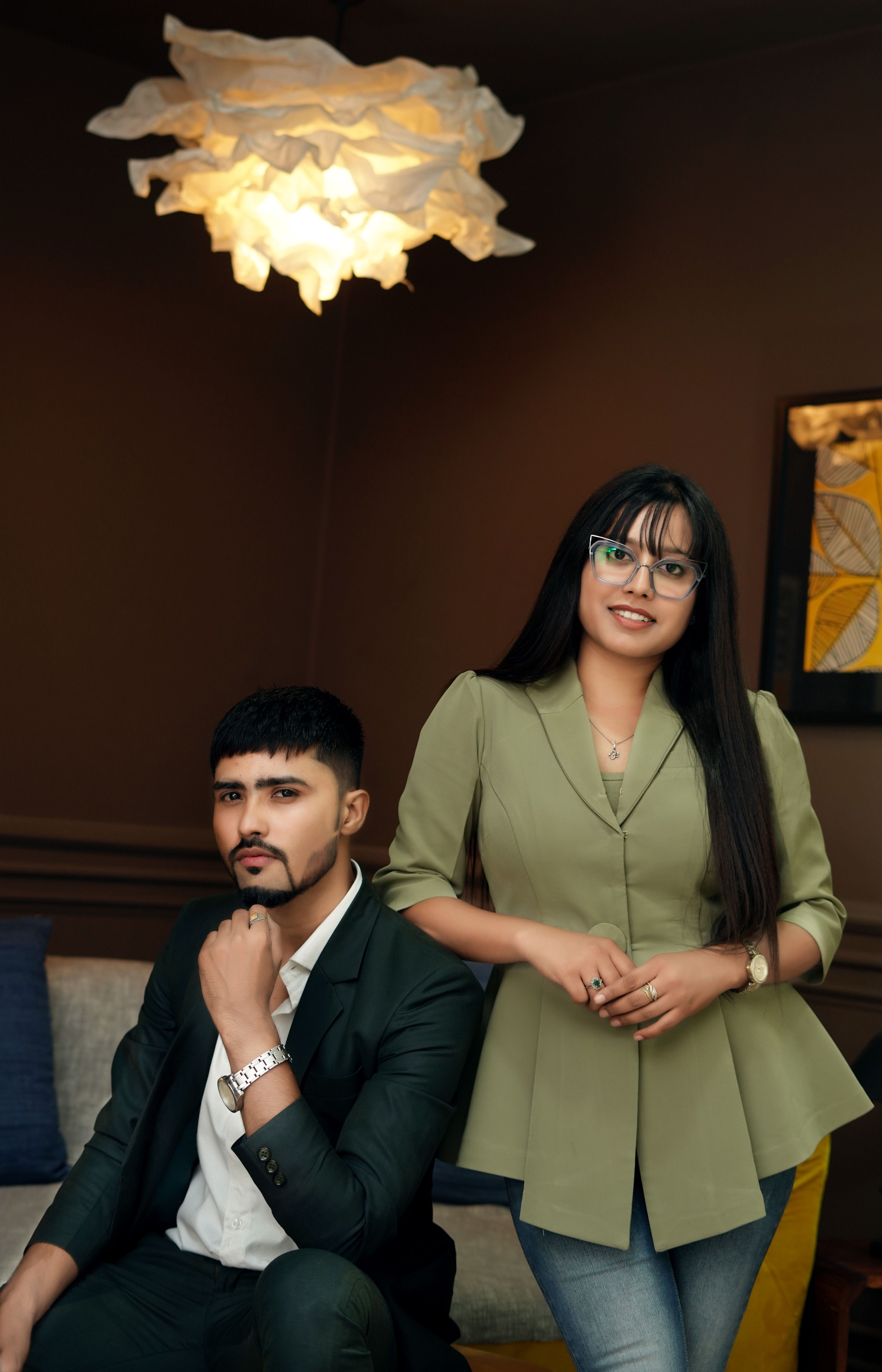 Fashion portrait featuring a man and woman posing elegantly indoors.