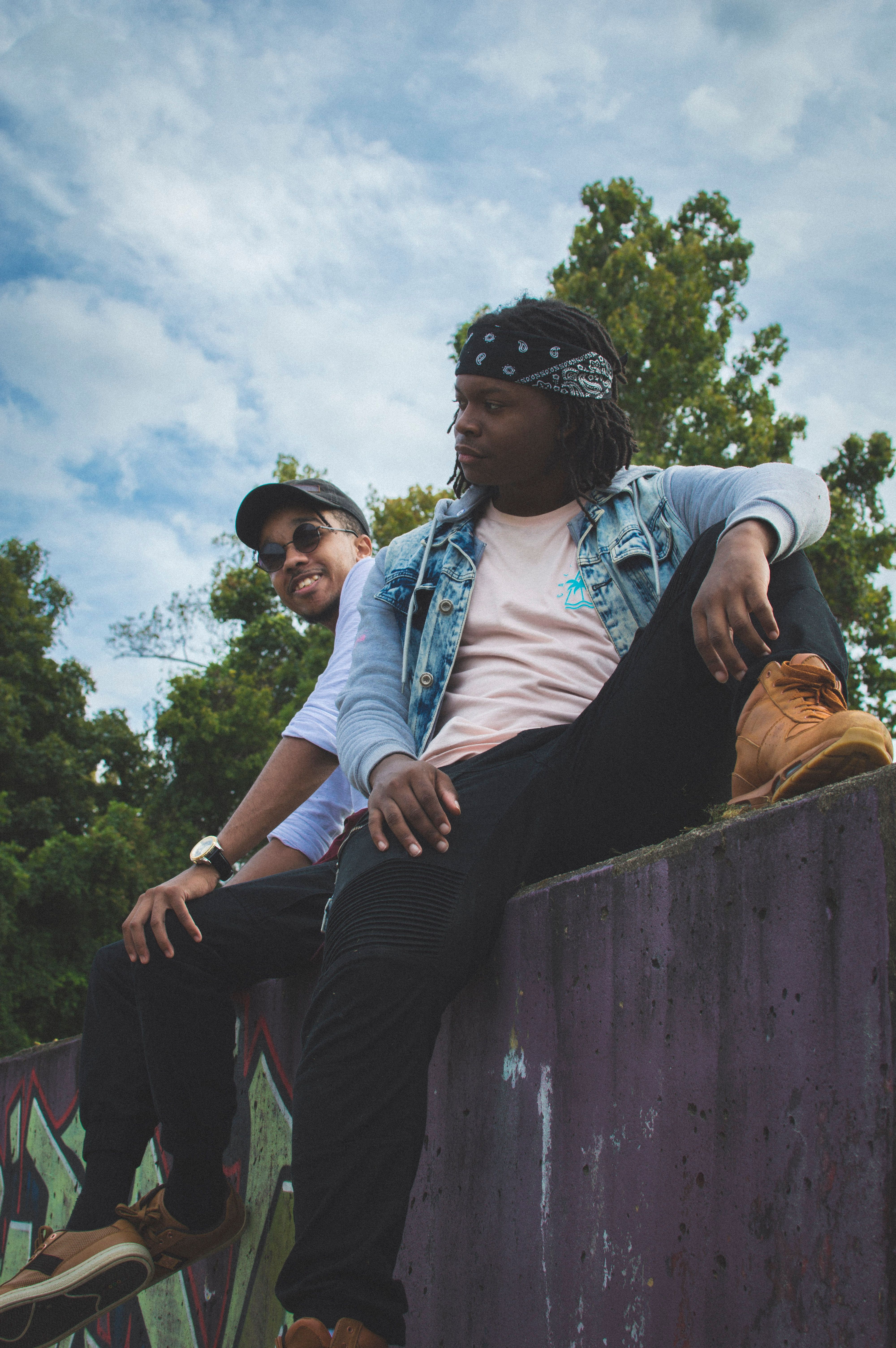 two men sitting on concrete pavement