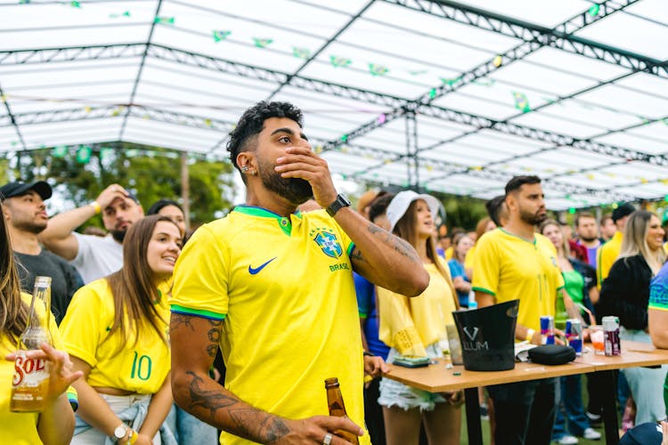 Fans Wearing Yellow T-Shirts Watching A Match