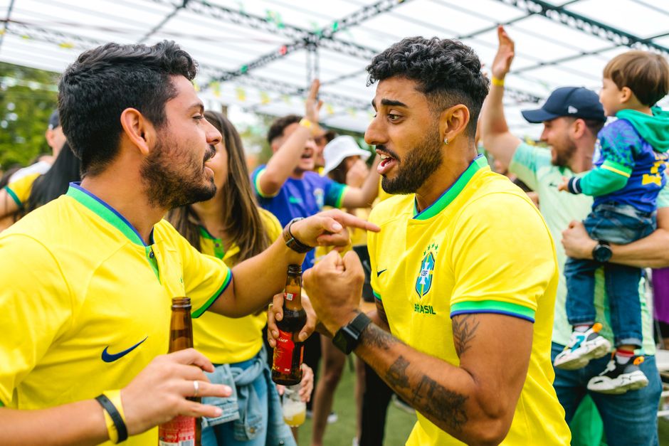 Cheerful soccer fans in yellow jerseys celebrating outdoors with excitement and joy.