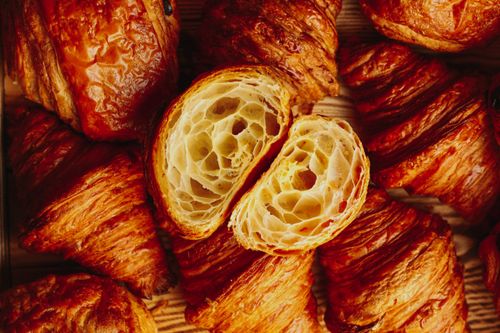Free Golden brown croissants showcasing flaky texture in a bakery setting. Stock Photo