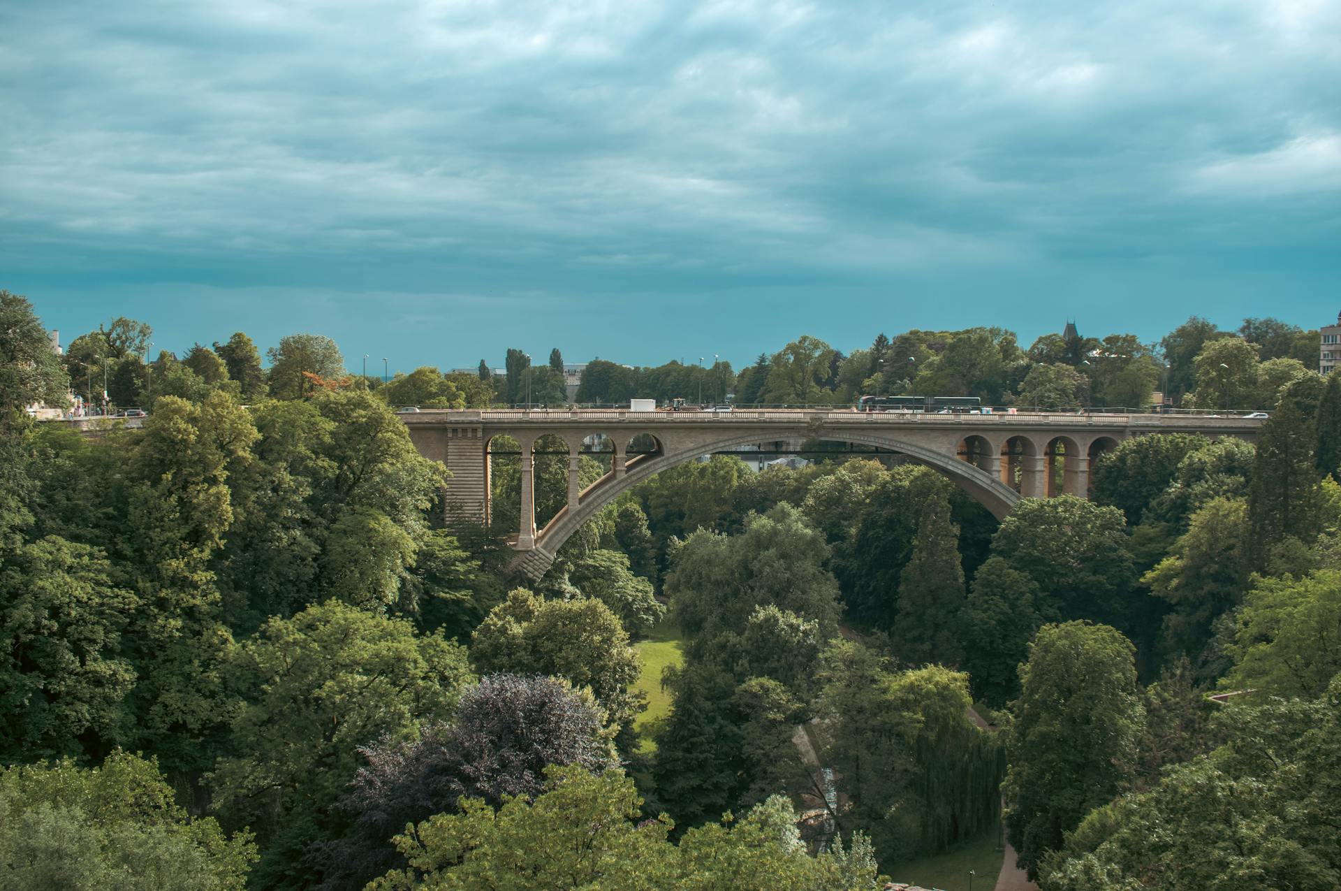 Stunning view of Adolphe Bridge surrounded by vibrant greenery in Luxembourg City.