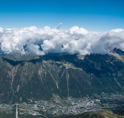 Aerial View of a Green Mountain Under White Clouds