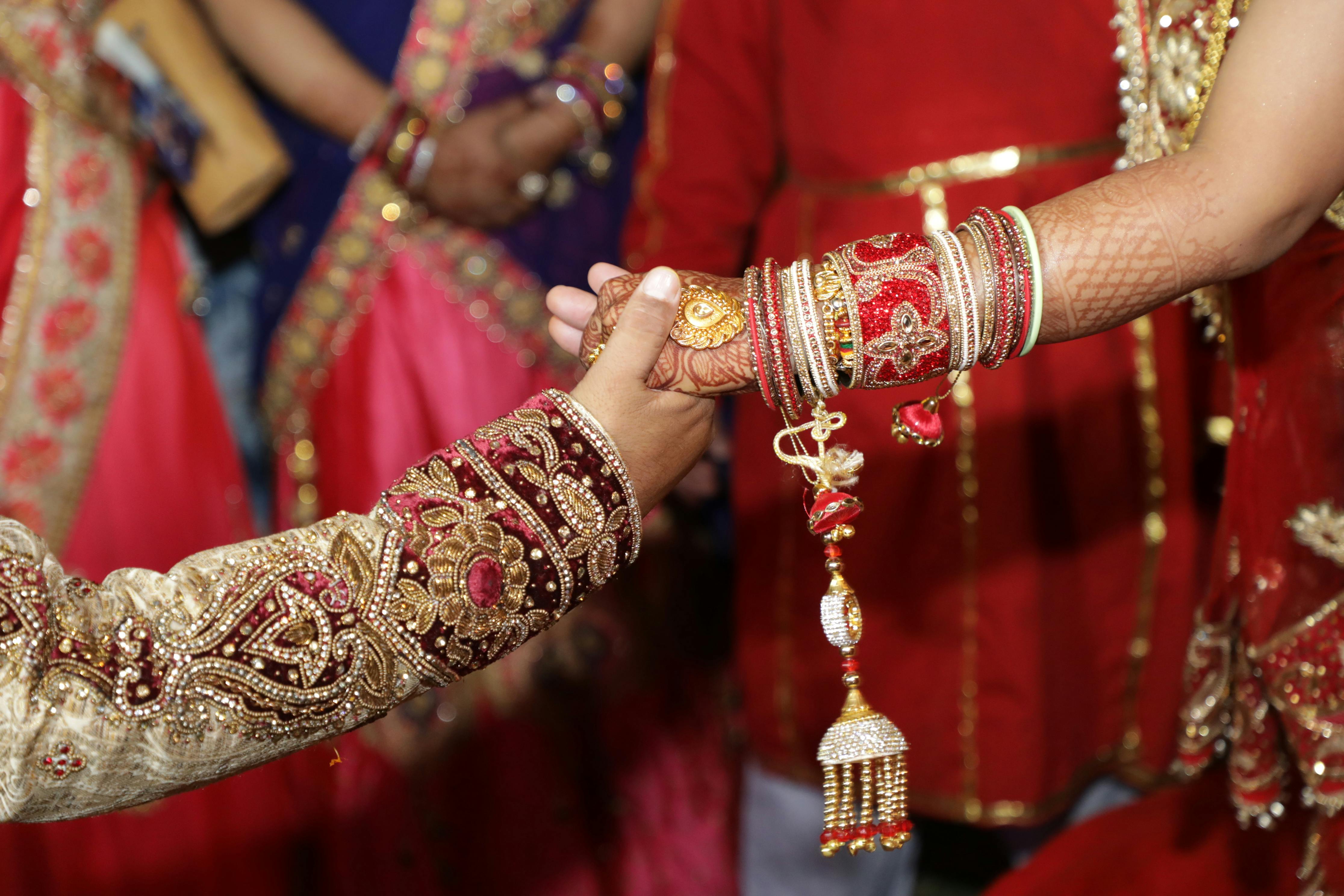 person holding hands wearing red and brown dress