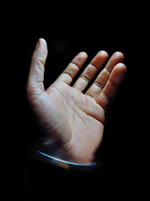 Free Detailed close-up of an open hand with soft lighting on black background. Stock Photo