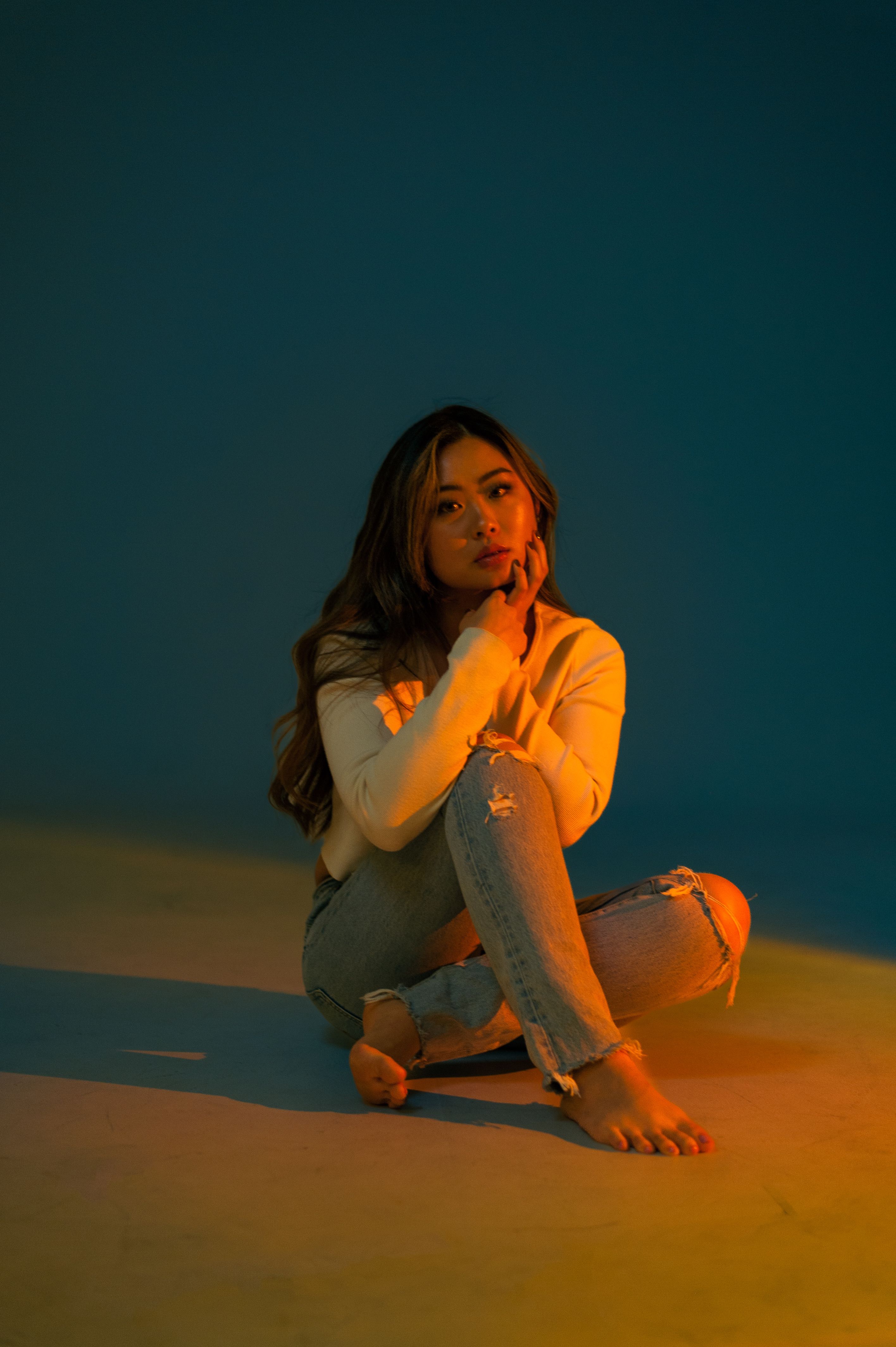 A Woman in Denim Jeans SItting on the Floor · Free Stock Photo