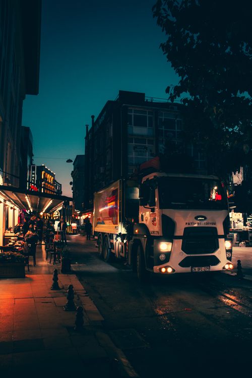 Free A night scene of a bustling Istanbul street featuring a white truck amidst vibrant city life. Stock Photo