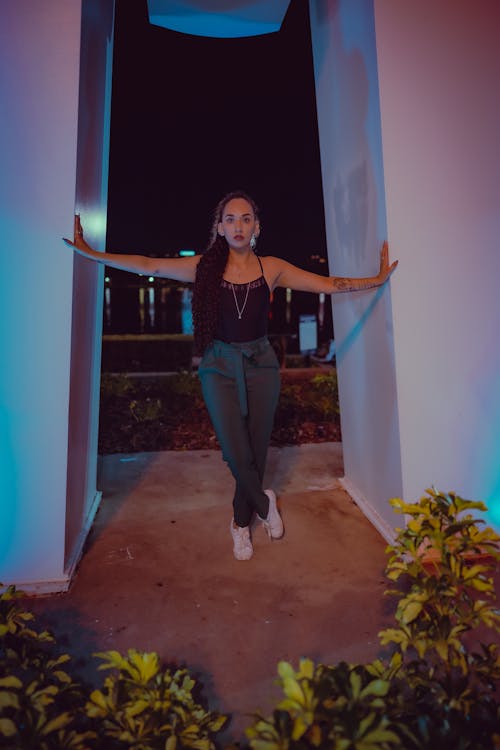 Woman in Black Tank Top Dancing Between the Columns