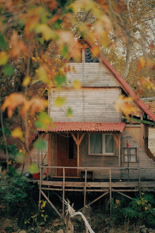 Free Cozy wooden cabin surrounded by vibrant autumn leaves, showcasing a serene fall atmosphere. Stock Photo