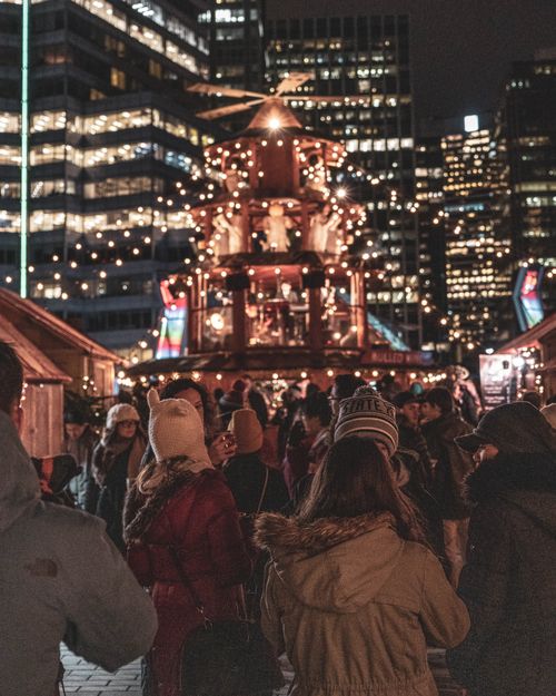 Free Nighttime view of a bustling Christmas market with festive lights and a joyful crowd in winter. Stock Photo