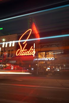 City street at night featuring vibrant neon signs and blurred motion effects.
