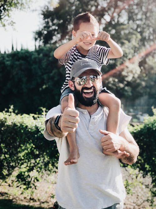 Free Man Carrying his Son over the Shoulders Stock Photo