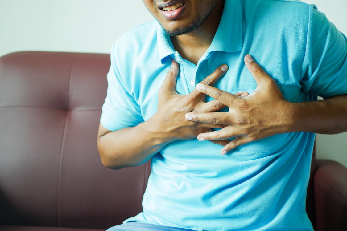 Free Close-up of a Man in Blue Polo Shirt with Hands on Chest Stock Photo