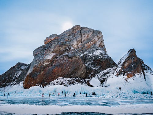 Rock on the Frozen Lake Baikal Surrounded by Tourists