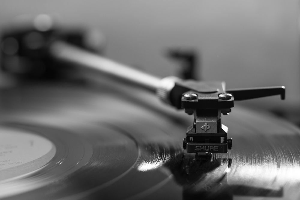 Close-up of a turntable needle riding a vinyl groove