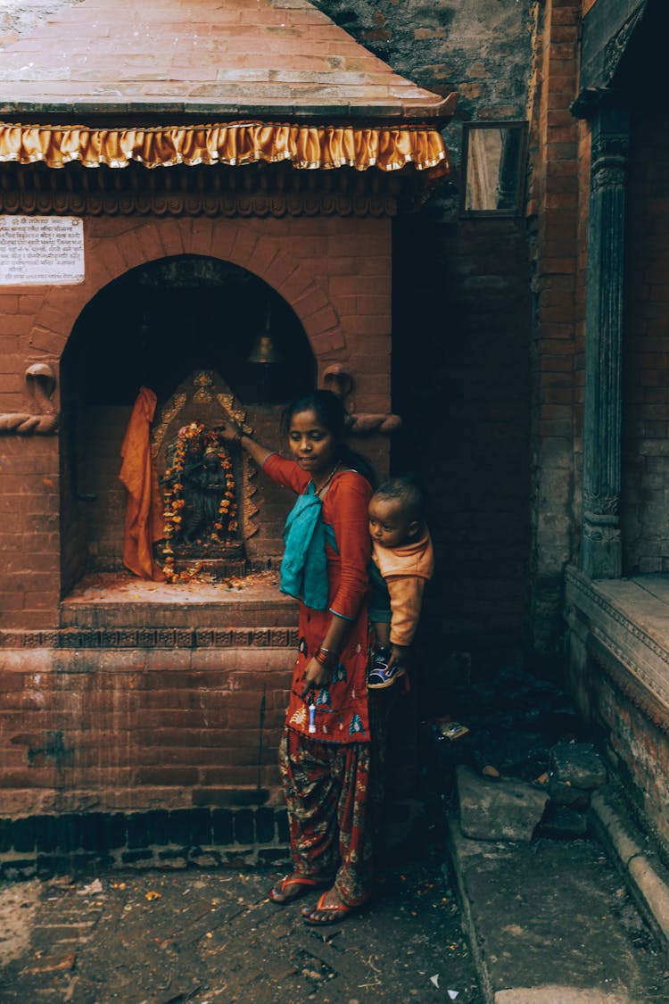 Girl Carrying Boy Near Shed