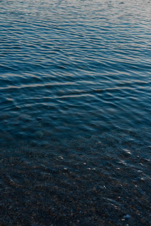Free Peaceful scene of small waves gently rippling against the shore, capturing a serene marine ambiance. Stock Photo