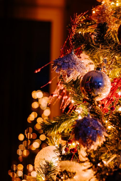 Free Beautifully decorated Christmas tree with shimmering ornaments and warm bokeh lights. Stock Photo