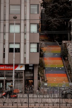 Vibrant staircase next to a modern building in urban setting with street elements.