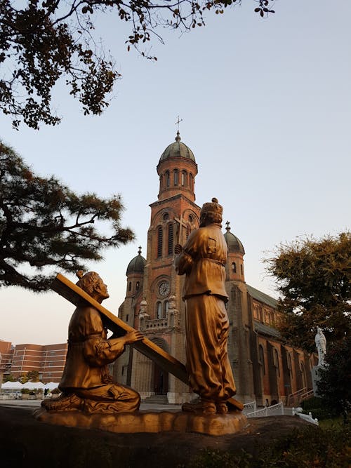 Golden Statues Near a Church Building