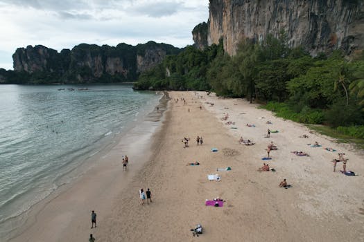 Aerial view of Railay Beach's sandy shores and lush cliffs in Thailand.