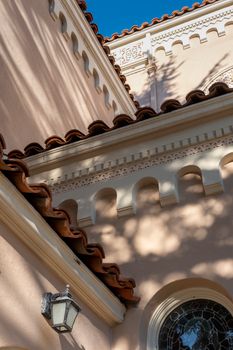 Angled view of Mediterranean architecture featuring red tile roof and detailed stucco work.