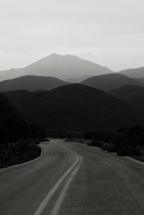A Grayscale of a Road and a Mountain Range