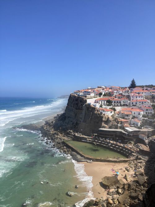 Free A breathtaking view of Azenhas do Mar village by the sea in bright sunlight, showcasing cliffs and blue ocean. Stock Photo